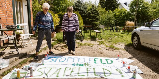 Zwei Frauen stehen vor einem Demo-Transparent mit der Aufschrift "Stoppelfeld statt Stapelfeld". Zwei Frauen stehen vor einem Demo-Transparent mit der Aufschrift "Stoppelfeld statt Stapelfeld".