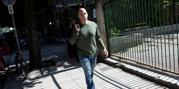Mann in Jeans und Shirt schreitet lässig mit Lederjacke über der Schulter Mann in Jeans und Shirt schreitet lässig mit Lederjacke über der Schulter