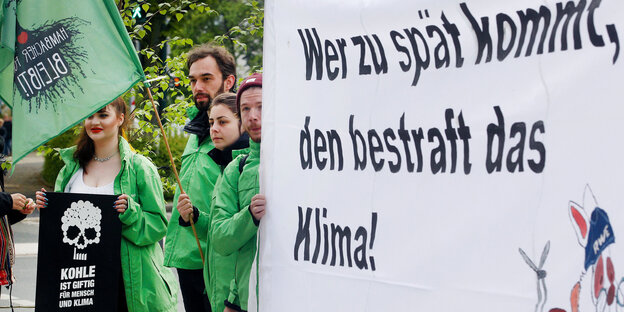 Demonstranten vor Beginn der RWE - Hauptversammlung mit einem Transparent . Demonstranten vor Beginn der RWE - Hauptversammlung mit einem Transparent .