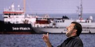 Matteo Salvini vor einer Videowand mit einem Bilder der Sea Watch