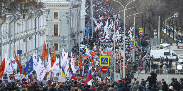 Tausende Menschen mit Fahnen auf einer Straße