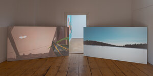 Zwei Landschaftsbilder stehen auf dem Boden, links und rechts von einer Tür, die in den nächsten Raum führt