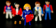 Eine weibliche und vier männliche Playmobil-Spielfiguren