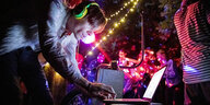 DJ am Laptop legt auf bei einer Party in der Berliner Hasenheide