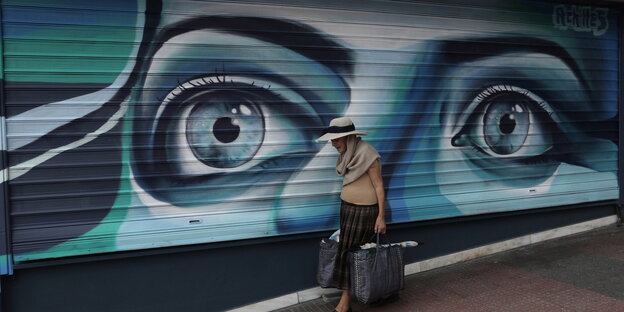 Einkäuferin vor großem Graffitto in Athen Einkäuferin vor großem Graffitto in Athen