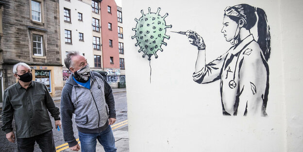 Edinburgh: Passanten gehen an dem öffentlichen Kunstwerk von «The Rebel Bear» vorüber, das eine Ärztin zeigt, die Impfstoff in ein Coronavirus injiziert