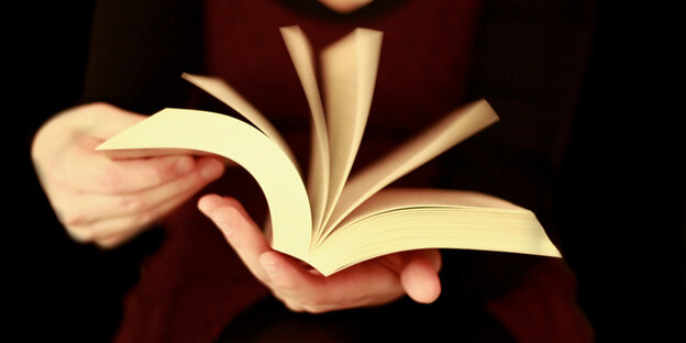 Hände halten ein aufgeschlagenes Buch Hände halten ein aufgeschlagenes Buch