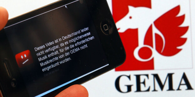 Ein Handy vor dem Gema-Logo zeigt ein gesperrtes Youtube-Video Ein Handy vor dem Gema-Logo zeigt ein gesperrtes Youtube-Video