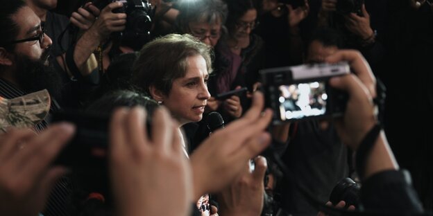 Die mexikanische Journalistin Carmen Aristegui umringt von Menschen mit Kameras