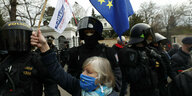 Eine Demonstrantin hält die EU-Flagge vor der russischen Botschaft in Prag hoch. Neben ihr ein polizeiliches Aufgebot
