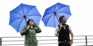 Annalena Baerbock und Robert Habeck mit blauen Regenschirmen