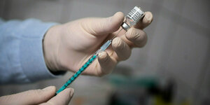 Ein Arzt zieht eine Spritze mit dem Impfstoff von Biontech/Pfizer auf