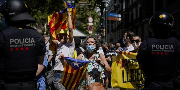 bei einer Demonstration halten eine Gruppe protestierende die katalonische Unabhängikeitsflagge hoch