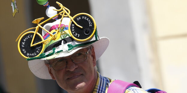 Tour-de-France-Fan mit gelbem Rennrad auf dem Panama-Hut Tour-de-France-Fan mit gelbem Rennrad auf dem Panama-Hut