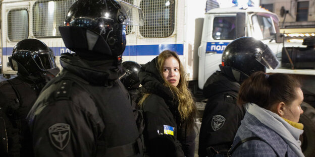 Eine Frau wird von Polizisten festgenommen.