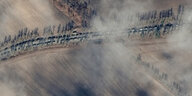 Luftaufnahme von einer Vielzahl von Militärfahrzeugen, die hintereinander über eine Landstraße fahren