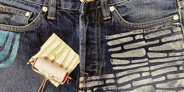 Eine Jeans wird mit einem Stempel bedruckt.