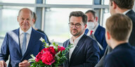 Olaf Scholz gratuliert einem sichtlich zerknirschten Thomas Kutschaty mit Blumenstrauß