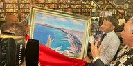 Macron schaut auf ein Gemälde der Hafenstadt Oran