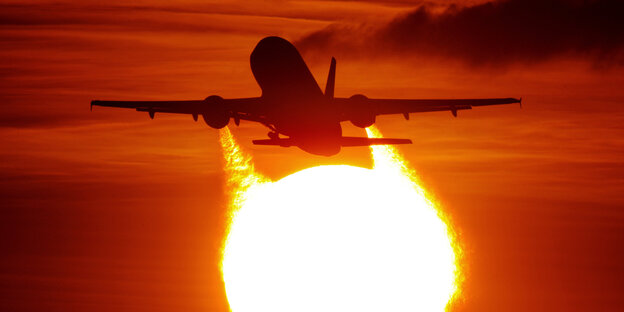 Ein Flugzeug startet vor der Sonne Ein Flugzeug startet vor der Sonne