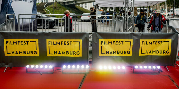 Beleuchteter Roter Teppich, Filmfest-Hamburg-Schilder an einer Absperrung