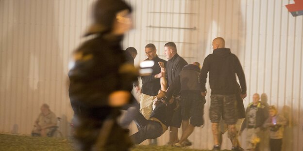 Ein Polizist geht an einigen Nazis vorbei Ein Polizist geht an einigen Nazis vorbei