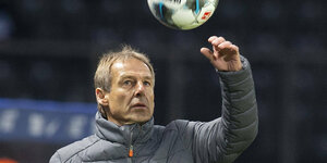 Jürgen Klinsmann greift mit dem Arm nach einem Ball in der Luft