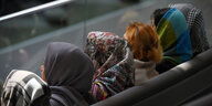 Frauen mit verschiedenfarbigen Kopftüchern sitzen als Zuschauerinnen im Bundestag.