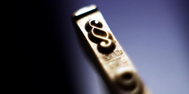 Metallstück mit Paragrafensymbol Metallstück mit Paragrafensymbol