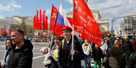 Junge Menschen tragen russische und rote Fahnen durch Moskau