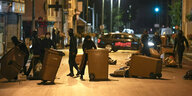 Vermummte Jugendliche ziehen Mülltonnen auf die Straße