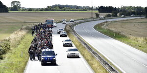 Eine Gruppe Flüchtlinge auf der Autobahn