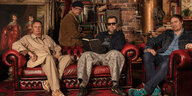 die vier Musiker des Bandprojekts Creep Show sitzen auf einem alten roten Sofa