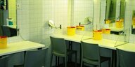 Blick in den Fixpunkt: Tische mit Spiegeln, einem Stuhl und einem gelben Eimer für den Müll nach der Drogeneinnahme