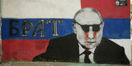 Wladimir Putin auf einem Wandbild mit dem russischen Wort für "Bruder", beschmiert