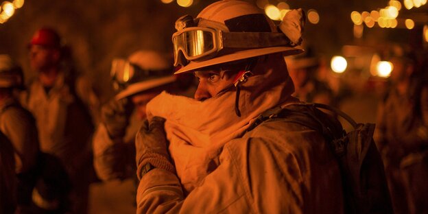 Ein Feuerwehrmann in Kalifornien bedeckt sein Gesicht mit einem Tuch. Ein Feuerwehrmann in Kalifornien bedeckt sein Gesicht mit einem Tuch.