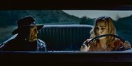 Eva Hassmann und Willie Nelson fahren in einem alten Auto durch die Wüste.