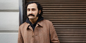 Porträt des Autors Amir Gudarzi mit schwarzem Schnurbart