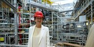 Bettina Stark-Watzinger (FDP), Bundesforschungsministerin steht mit rotem Helm vor der Kernfusions-Forschungsanlage "Wendelstein 7-x" in Greifswald