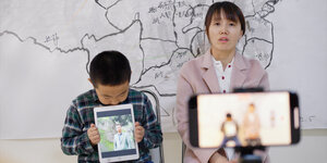 Zijuan Chen und ihr Sohn setzen sich für die Freilassung ihres Mannes mit Protestschildern ein