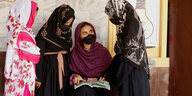 Vier afghanische Mädchen mit Kopftüchern und Mudschutz im Gespräch nach einer Schulstunde im nordwestpakistanischen Peshawar.