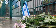 Blumen und eine israelische Fahne sind nach dem Angriff auf Israel vor der jüdischen Synagoge in Hamburg abgelegt worden.