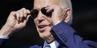 Präsident Joe Biden setzt sich eine Sonnenbrille auf.