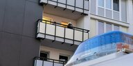 Die Polizei arbeitet in einem Haus in Duisburg auf dem Balkon. Im Vordergrund steht ein Polizeiauto