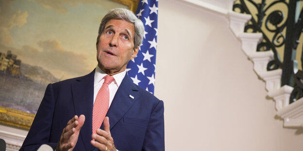 Kerry steht vor einer USA-Flagge und redet zur Presse Kerry steht vor einer USA-Flagge und redet zur Presse