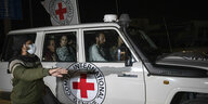Ein Wagen des roten Kreuzes mit Fahne, davor ein Soldat