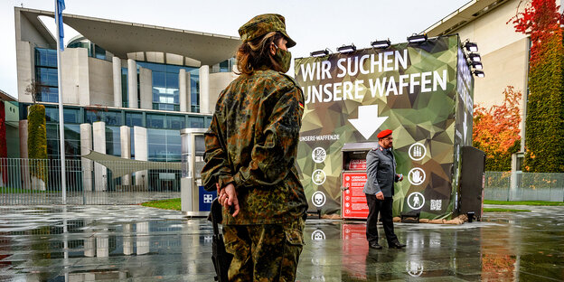 Ein Mann und eine Frau in Bundeswehruniformen vor dem Kanzleramt in Berlin