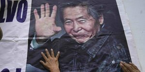 Mehrere Hände berühren ein Foto des inhaftierten Ex-Präsidenten Alberto Fujimori