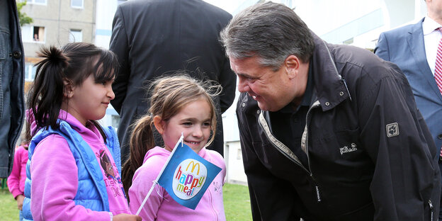 Sigmar Gabriel spricht mit zwei Flüchtlingsmädchen. Sigmar Gabriel spricht mit zwei Flüchtlingsmädchen.