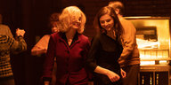 Dr. Rebecca Saint John (Anne Hathaway) und Eileen (Thomasin McKenzie) tanzen lächelnd vor einer Jukebox.